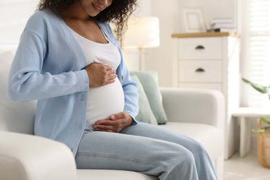 Pregnant woman on sofa at home, closeup