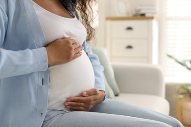 Photo of Pregnant woman on sofa at home, closeup