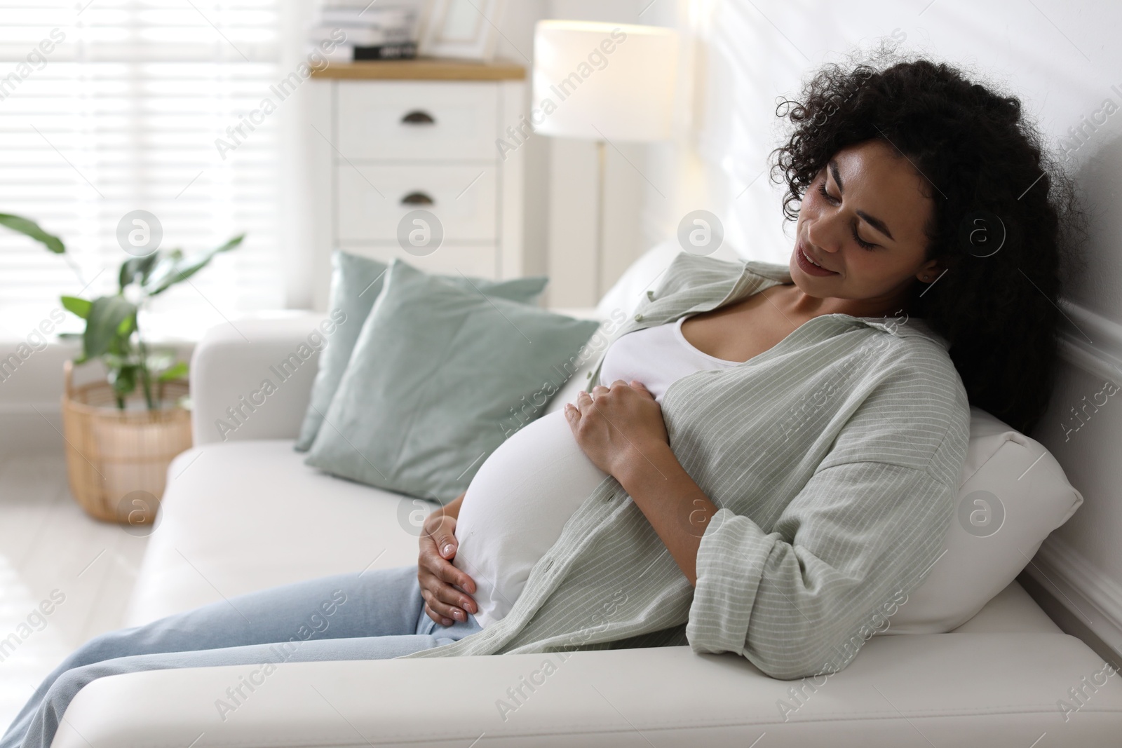 Photo of Portrait of beautiful pregnant woman on sofa at home