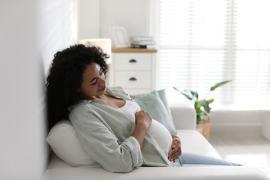 Photo of Portrait of beautiful pregnant woman on sofa at home