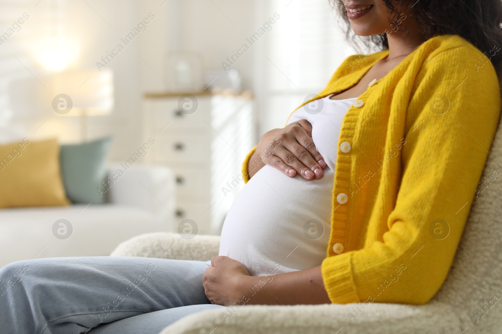 Photo of Pregnant woman on sofa at home, closeup