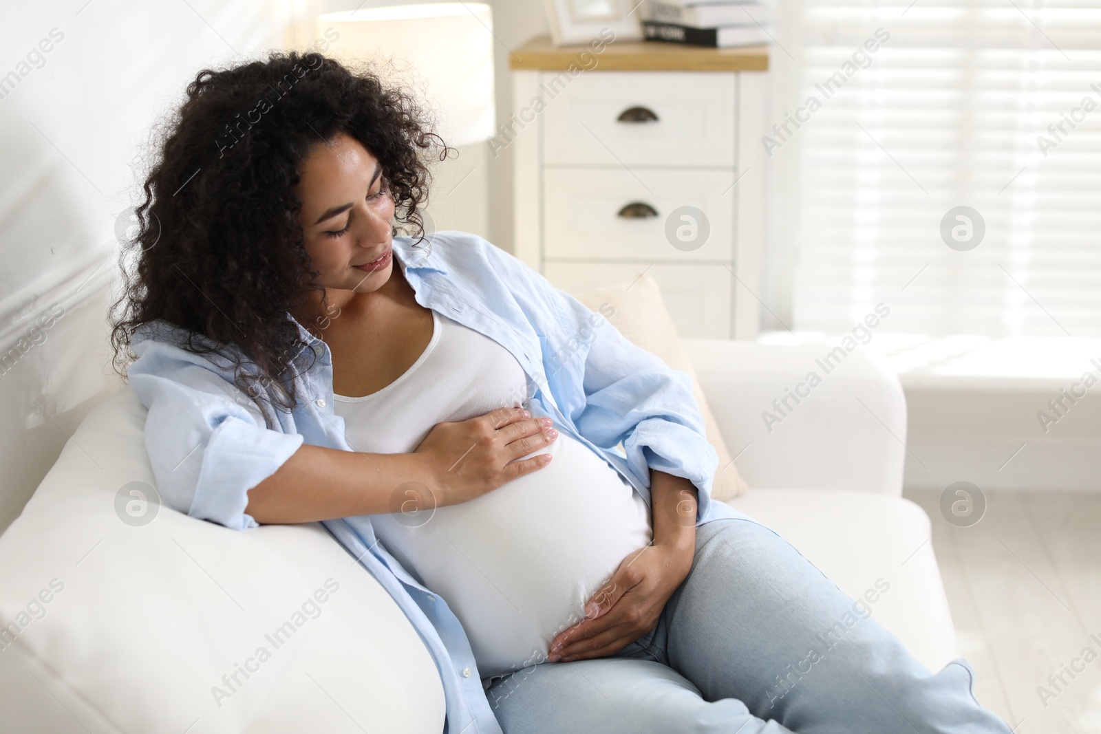 Photo of Portrait of beautiful pregnant woman on sofa at home