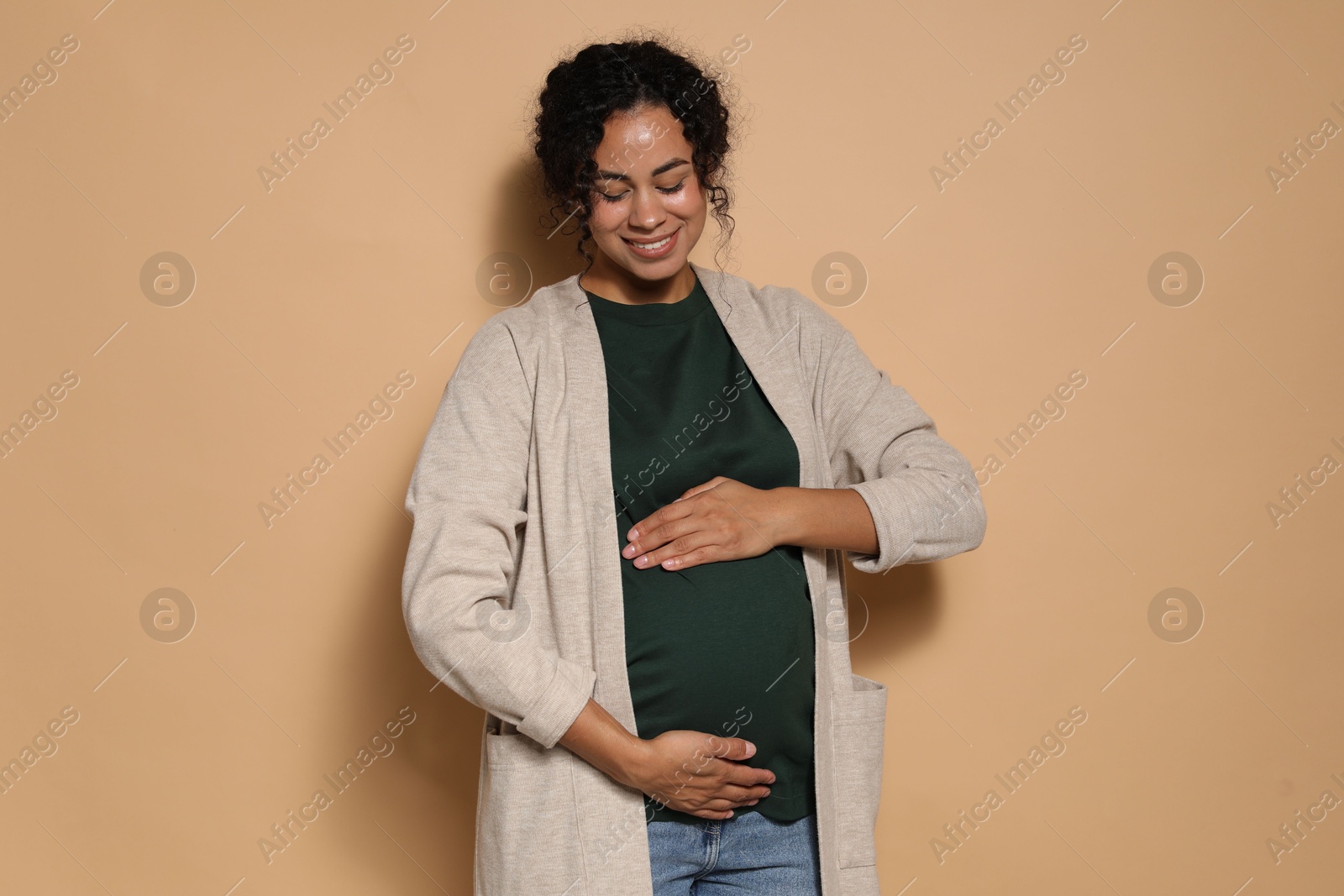 Photo of Portrait of beautiful pregnant woman on beige background