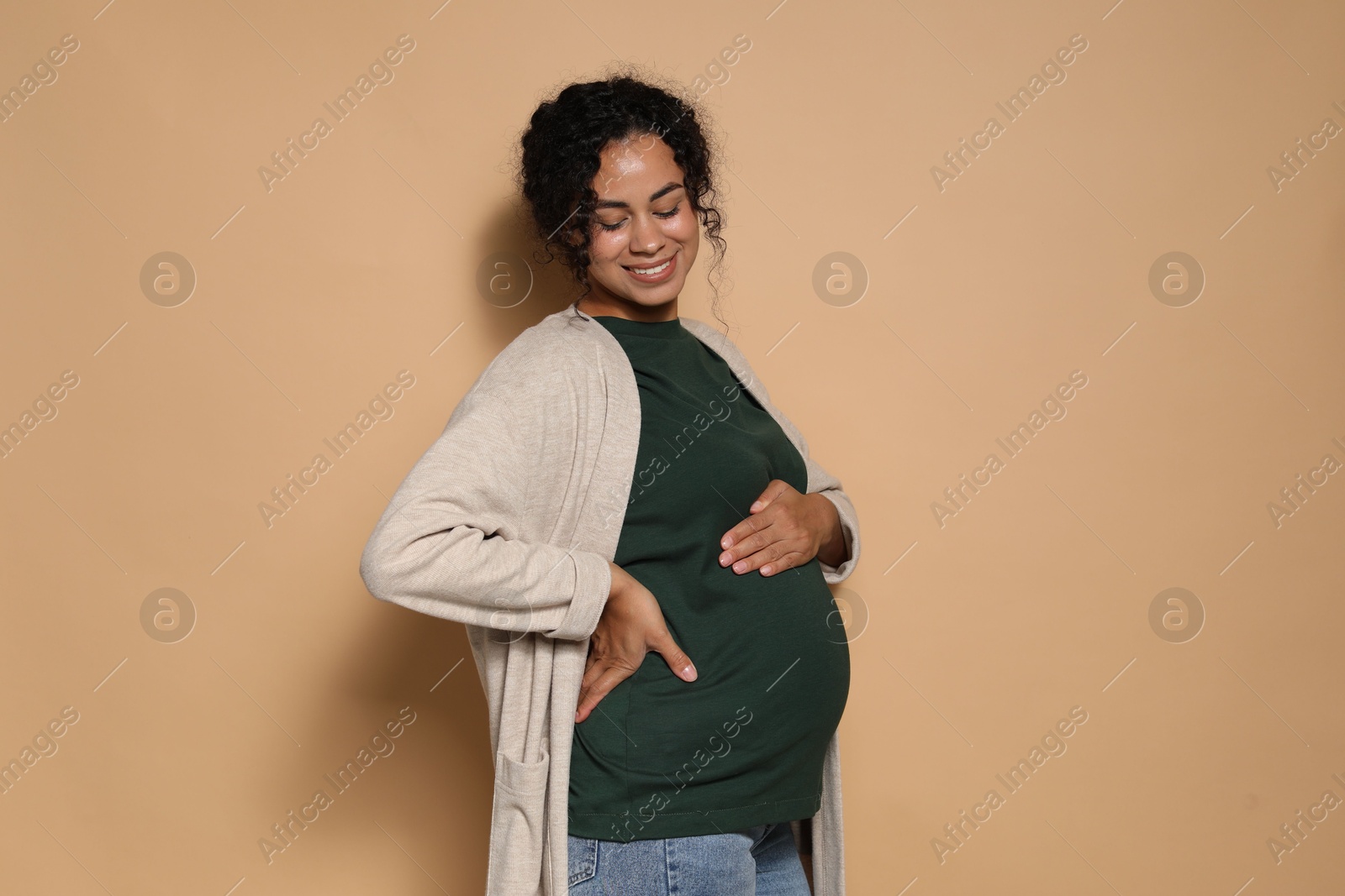 Photo of Portrait of beautiful pregnant woman on beige background