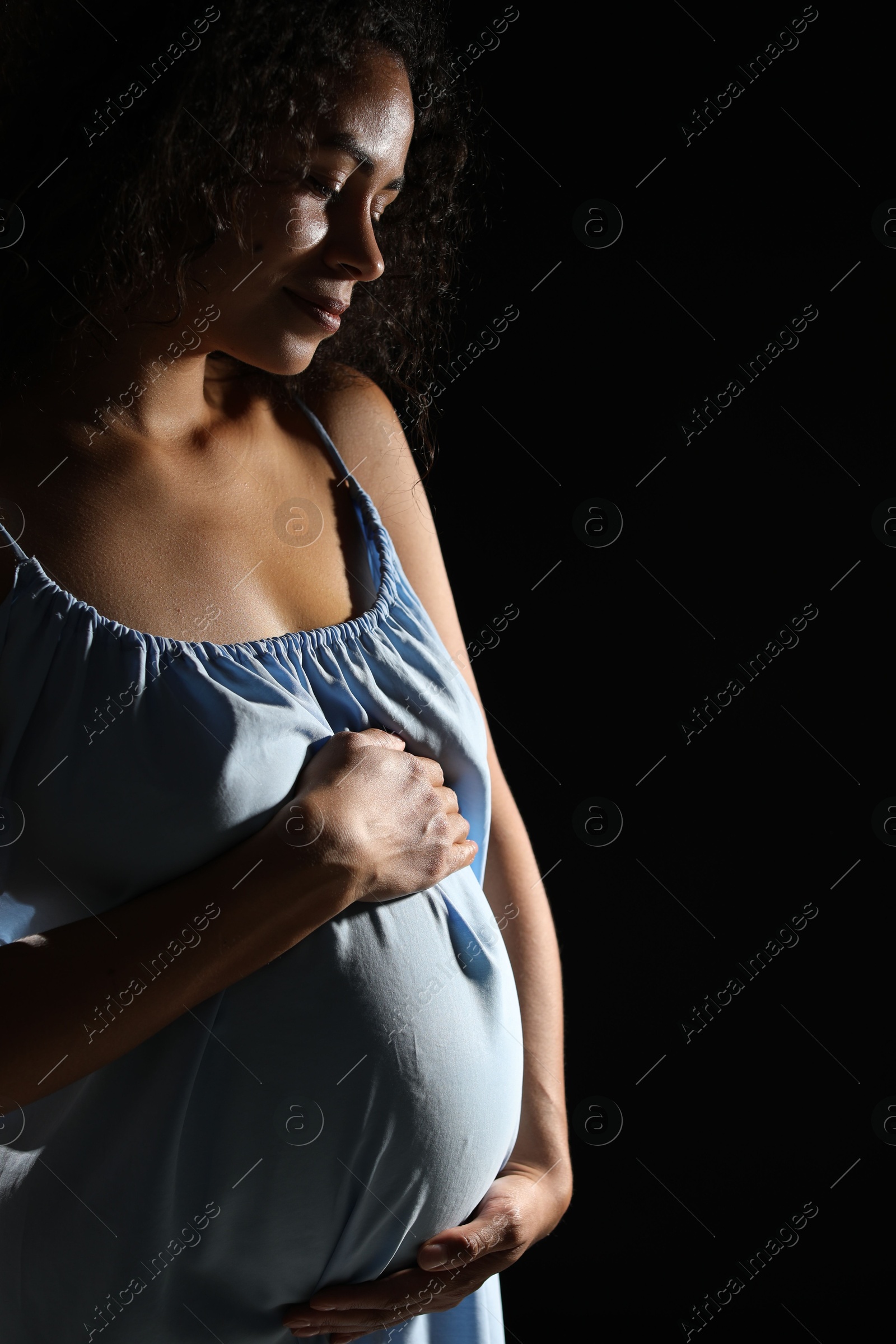 Photo of Portrait of beautiful pregnant woman on black background