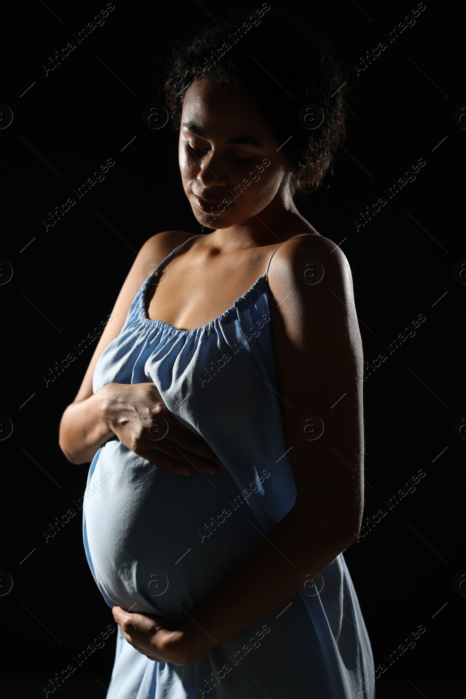 Photo of Portrait of beautiful pregnant woman on black background