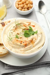 Delicious hummus with paprika, pita and chickpeas on table, closeup