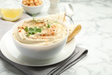 Photo of Delicious hummus with paprika and pita on white marble table, closeup