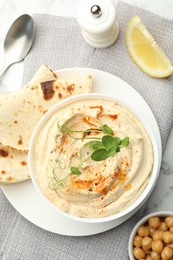 Photo of Delicious hummus with paprika, pita and chickpeas on table, top view