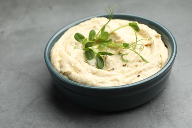 Photo of Delicious hummus in bowl on grey table, closeup