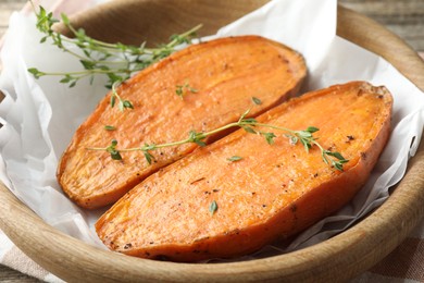 Photo of Tasty cooked sweet potato with thyme on table, closeup