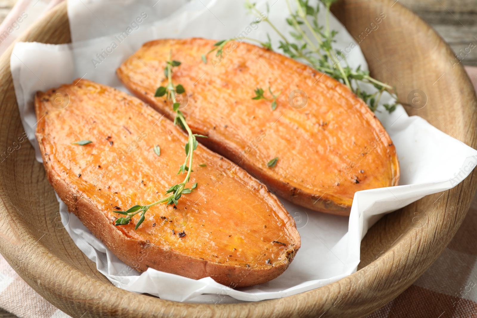 Photo of Tasty cooked sweet potato with thyme on table, closeup