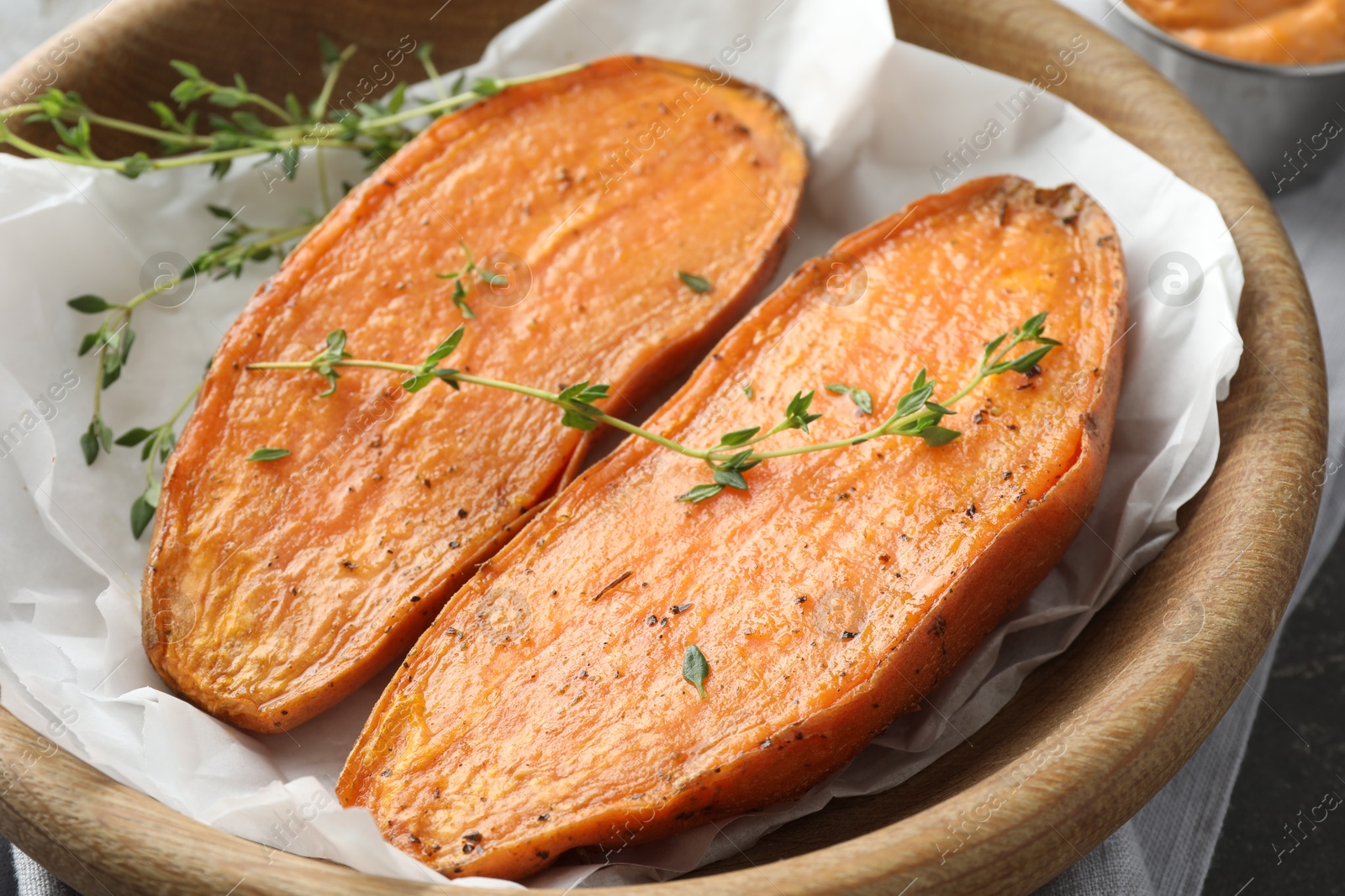 Photo of Tasty cooked sweet potato with thyme on table, closeup