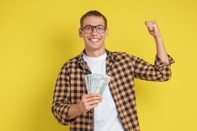 Photo of Happy man with money on yellow background