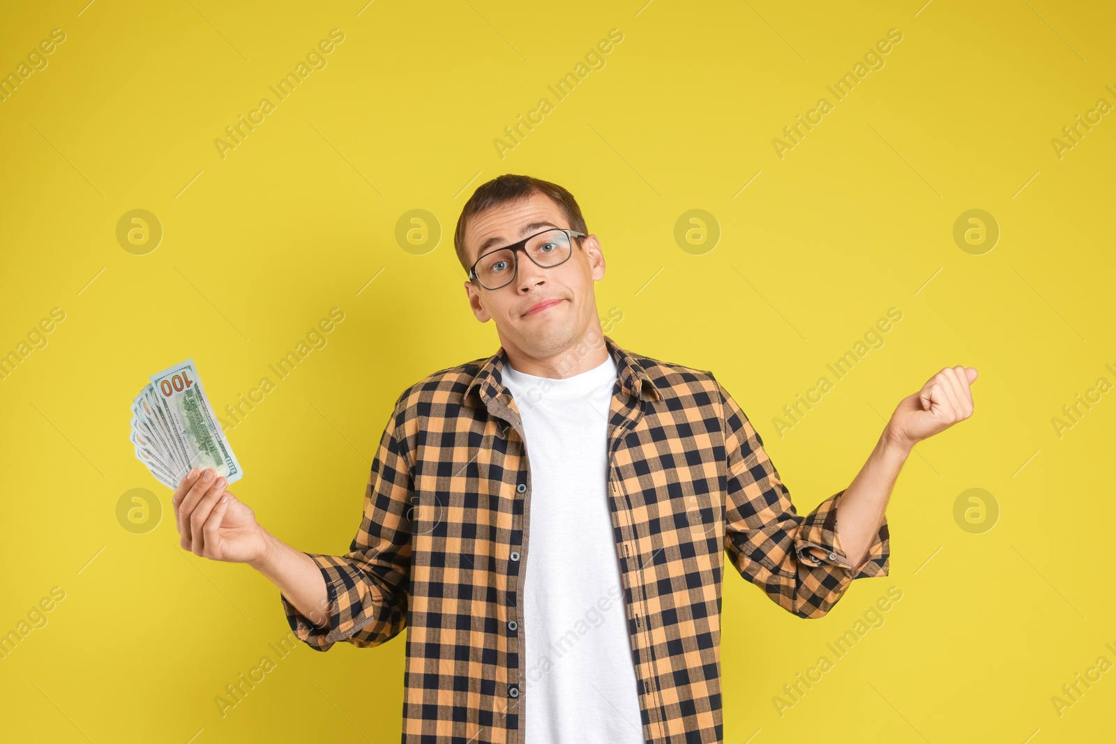 Photo of Man with dollar banknotes on yellow background