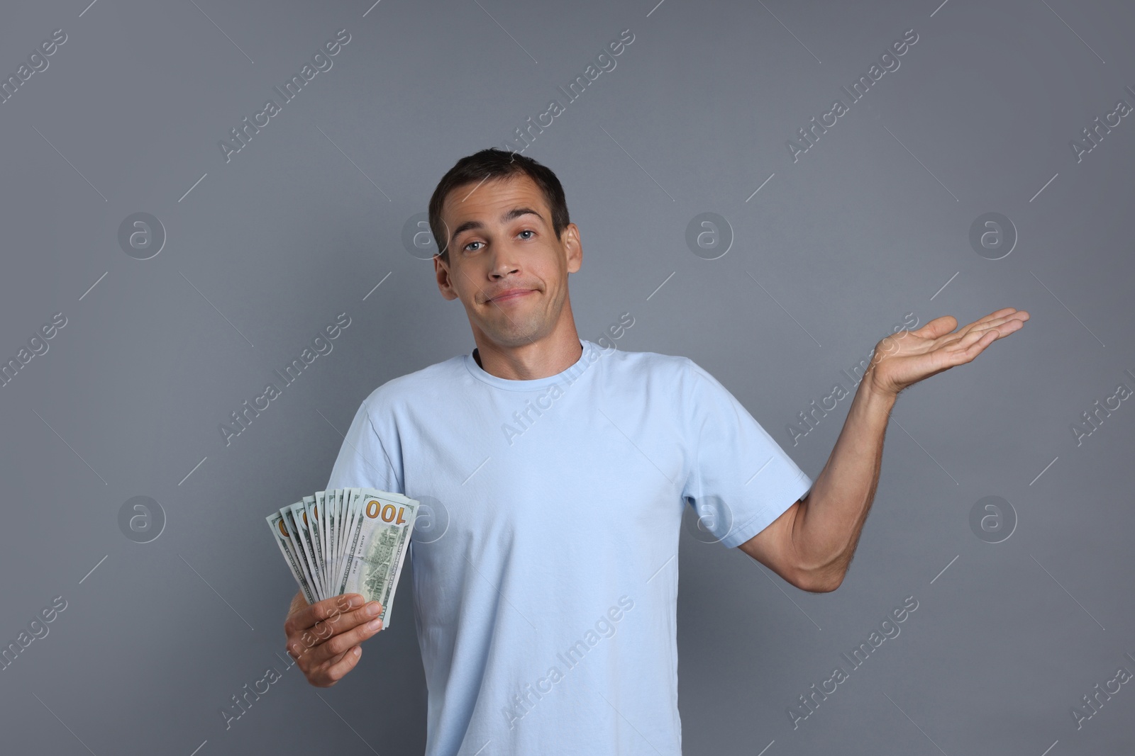 Photo of Man with dollar banknotes on grey background