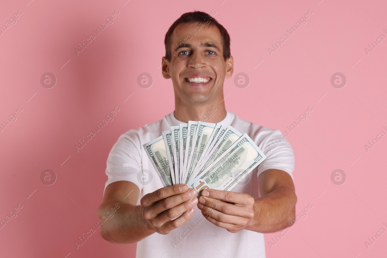 Photo of Happy man with money on pink background