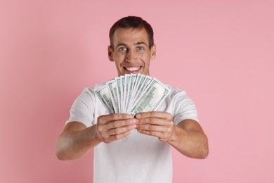 Man with dollar banknotes on pink background