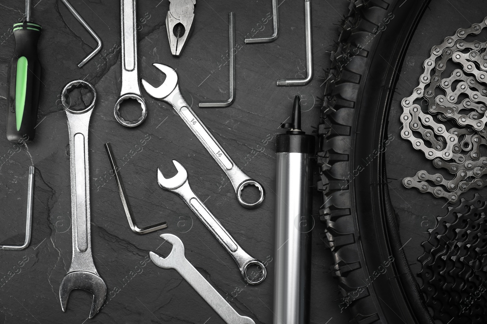 Photo of Parts of bicycle and tools on black table, flat lay