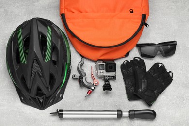 Bicycle accessories and equipment on grey textured background, flat lay