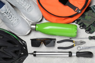 Bicycle accessories and tools on grey textured background, flat lay