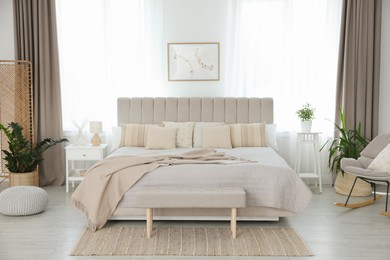 Photo of Big comfortable bed in room. Interior design