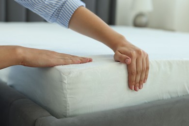 Woman changing clean bed linens at home, closeup