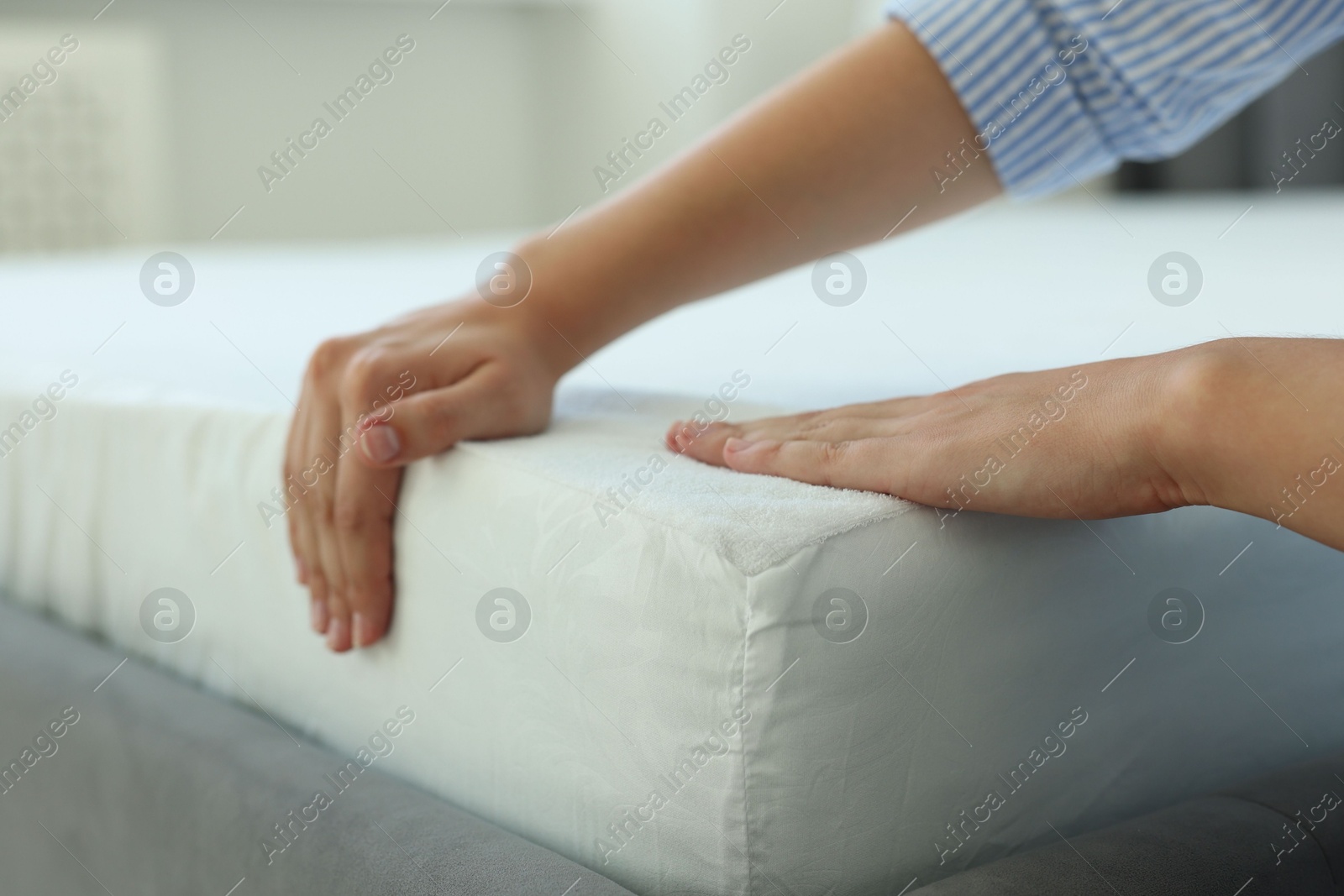 Photo of Woman changing clean bed linens at home, closeup