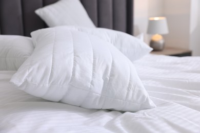 Photo of Bed with clean linens and pillows at home, closeup