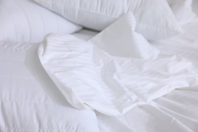 Photo of Bed with clean linens and pillows at home, closeup