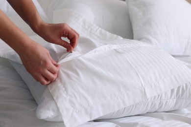 Photo of Woman changing clean bed linens at home, closeup