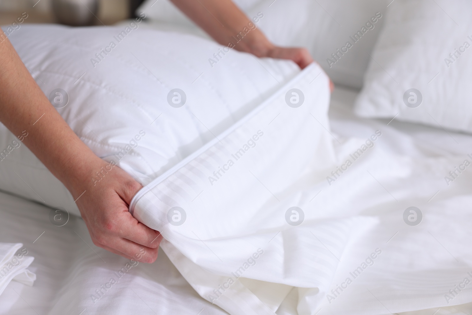 Photo of Woman changing clean bed linens at home, closeup