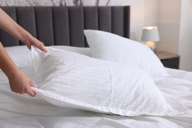 Photo of Woman changing clean bed linens at home, closeup