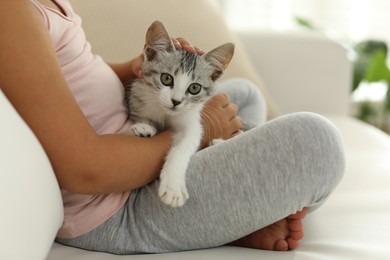 Photo of Little girl with cute kitten at home, closeup