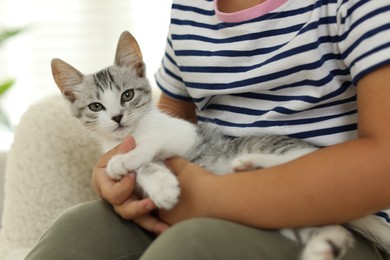 Photo of Little girl with cute kitten at home, closeup