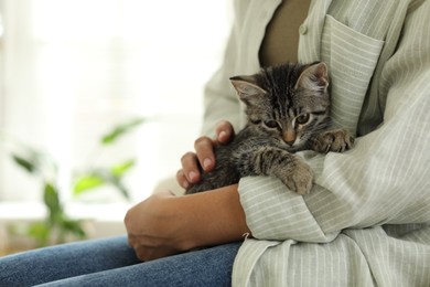 Woman with cute kitten at home, closeup