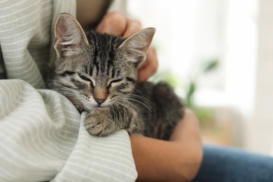 Photo of Woman with cute kitten at home, closeup