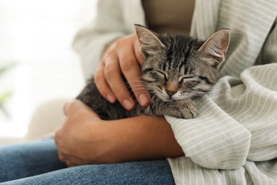 Photo of Woman with cute kitten at home, closeup