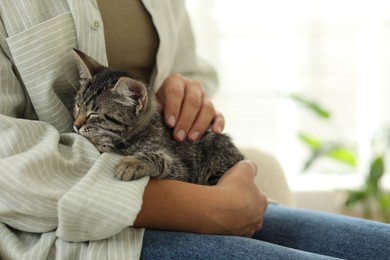 Photo of Woman with cute kitten at home, closeup