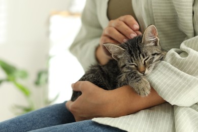 Photo of Woman with cute kitten at home, closeup