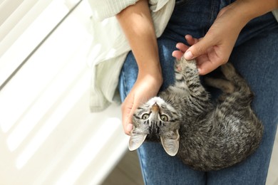 Photo of Woman with cute kitten at home, top view