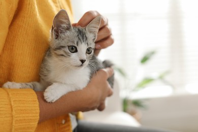 Photo of Woman with cute kitten at home, closeup. Space for text