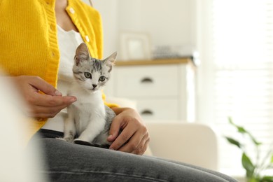 Photo of Woman with cute kitten at home, closeup. Space for text