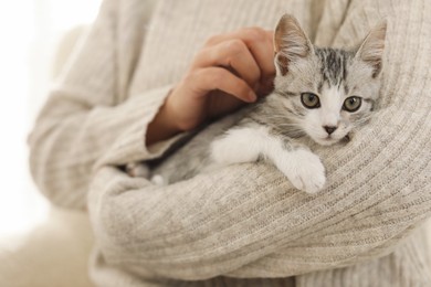 Photo of Woman with cute kitten at home, closeup