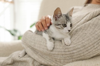 Photo of Woman with cute kitten at home, closeup