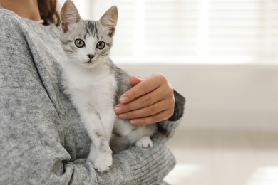 Photo of Woman with cute kitten at home, closeup. Space for text