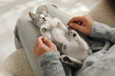 Woman with cute kitten at home, above view