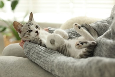 Photo of Woman with cute kitten at home, closeup