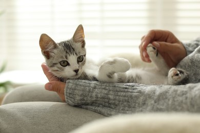 Photo of Woman with cute kitten at home, closeup