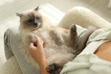 Photo of Woman with cute kitten at home, closeup